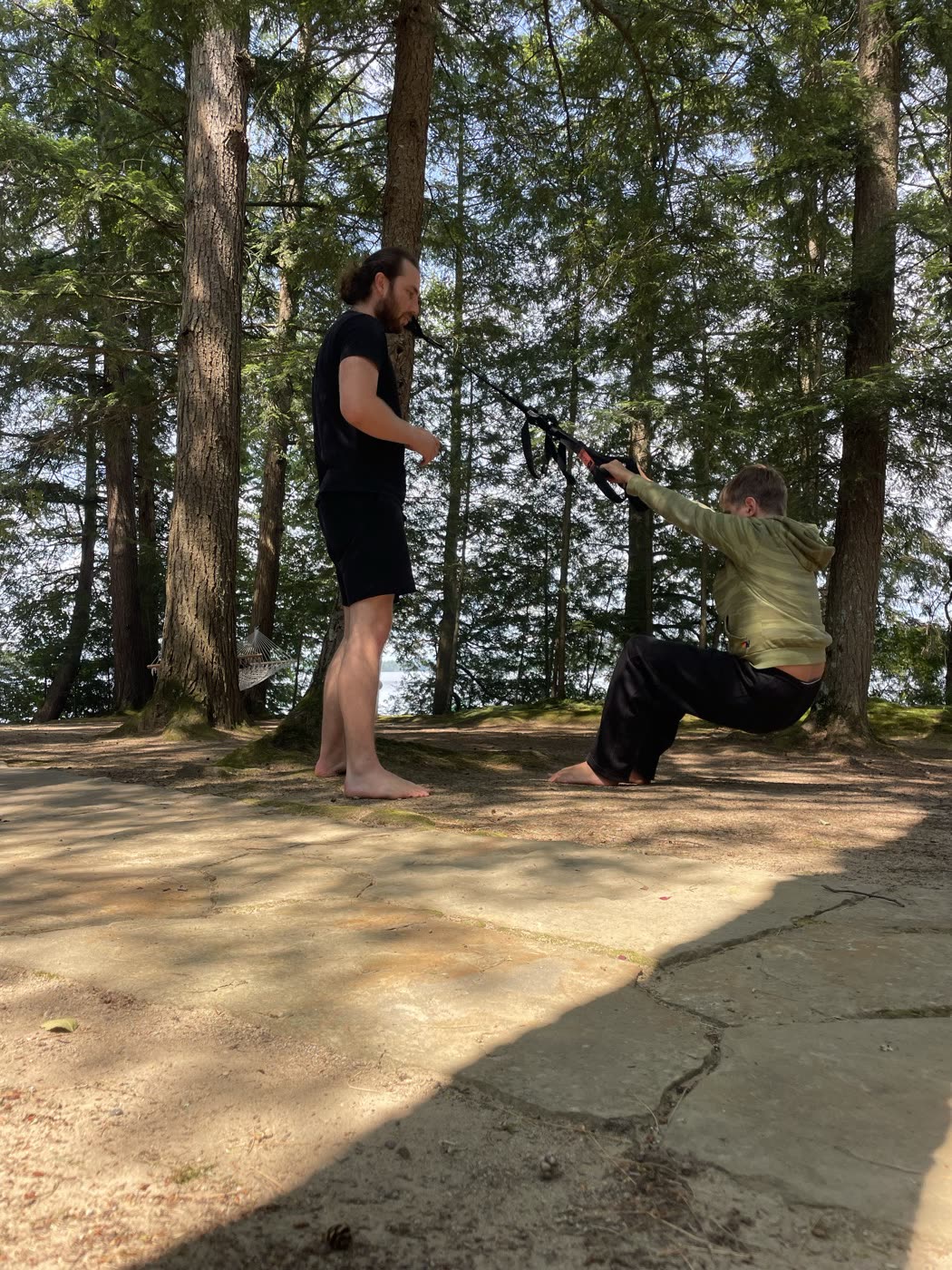 Dillon coaching a young person through a TRX session